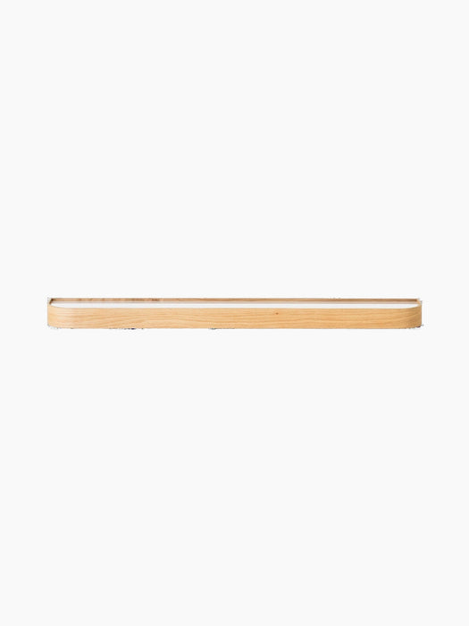 Epoch Shelf in natural oak. The long, minimalist wall shelf has a white interior and is set against a black background.