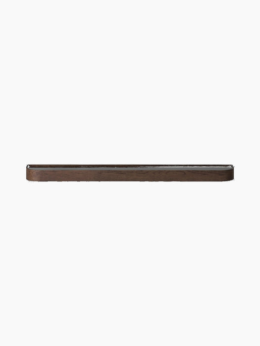 Audo CPH Échasse Shelf in dark oak, a long, thin wooden shelf with rounded corners, shown against a black background.