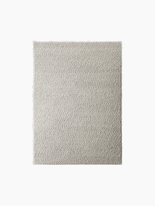 A top-down shot of the Gravel Rug in grey, shown in full against a solid black background, highlighting its nubby texture.