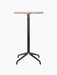 Front view of the Harbour Column Bar Table with a round Kunis Brescia stone top and a sleek black star-shaped base.