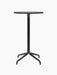 Front view of the Harbour Column Bar Table with a round black oak top, slender black central column, and a star-shaped base.