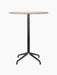 Front view of the Harbour Column Bar Table with a round Kunis Breccia stone top and a black star base on a black background.