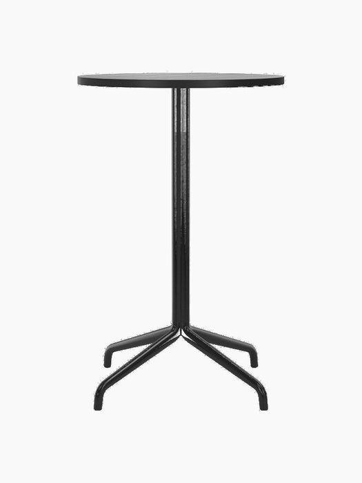 A front view of the all-black Harbour Column Counter Table, which has a round black oak top and a slender star-shaped base.