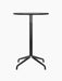 A front view of the all-black Harbour Column Counter Table, which has a round black oak top and a slender star-shaped base.