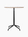 A front view of the Harbour Column Counter Table, featuring a round Kunis Breccia stone top and a black metal star base.
