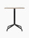 Front view of the Harbour Column Dining Table featuring a rectangular Kunis Brescia stone top and a black metal star base.