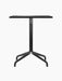 Front view of the Harbour Column Dining Table with a rectangular charcoal linoleum top and a black star-shaped base.