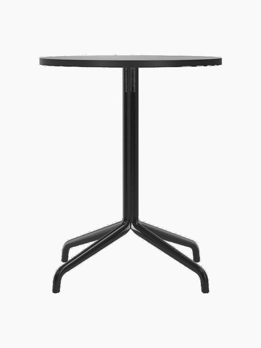 A front view of the Harbour Column Dining Table with a round black oak top and black star base, on a black background.