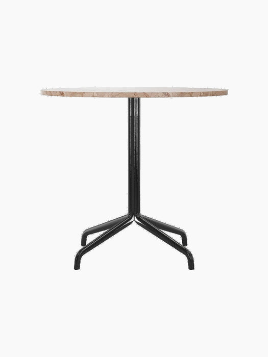 A front view of the Harbour Column Dining Table with a round Kunis Breccia stone top and black metal star-shaped base.