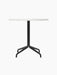 Front view of the Harbour Column Dining Table with a round, white Estremoz marble top and a black star-shaped metal base.