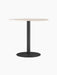 Front view of the Harbour Column Dining Table with a round, light-coloured top and a fluted black column on a round base.