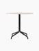 Harbour Column Dining Table, featuring a round Kunis Breccia stone top and a black powder-coated steel star base.