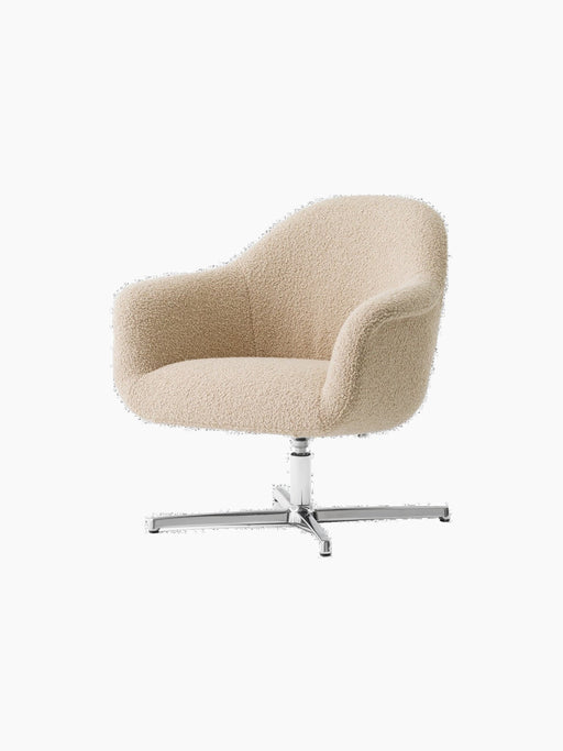An angled view of the Harbour Lounge Chair, with light beige bouclé upholstery and a polished aluminium star swivel base.