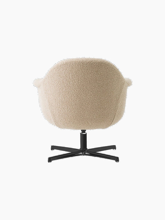 Back view of the Harbour Lounge Chair with light beige textured upholstery and a black, star-shaped swivel base.