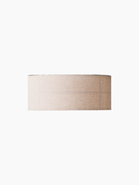 The Hashira Ceiling Lamp, Raw, seen from the side. It has a cylindrical, light-beige linen shade against a black background.