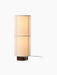 The Hashira Floor Lamp, Raw, shown turned on. It features a cylindrical linen shade with a grid pattern on a dark wood base.