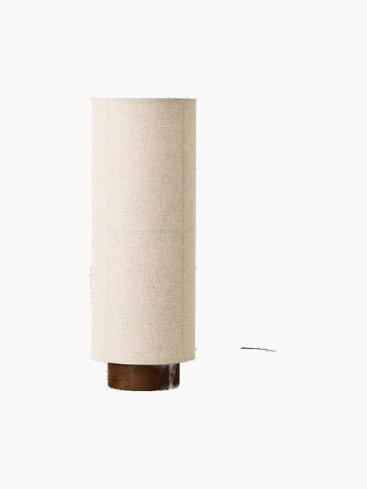 Front view of the Hashira Floor Lamp in Raw. The lamp has a tall, cylindrical, beige linen shade on a dark ash wood base.