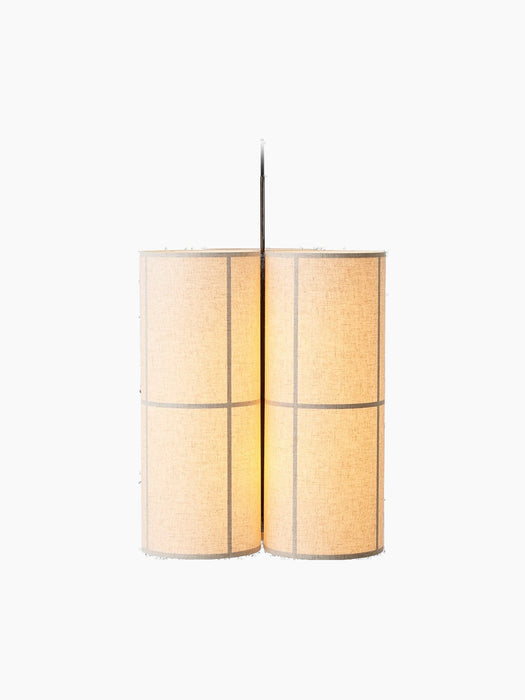 The Hashira Pendant Lamp, Cluster, seen from an angle. Three cylindrical linen shades glow warmly against a black background.