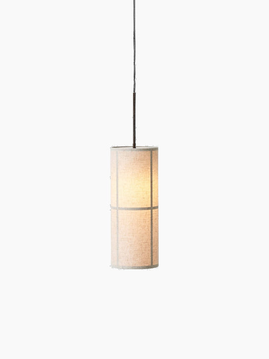 A lit Hashira Pendant Lamp with a cylindrical raw linen shade hangs against a black background, showing its inner structure.