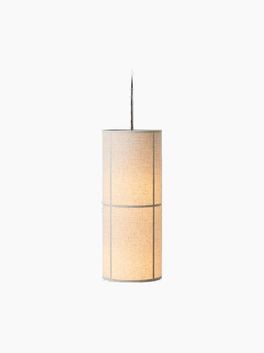 A lit Hashira Pendant Lamp with a cylindrical raw linen shade revealing its inner frame, against a black background.