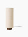 A front-on image of the Hashira Table Lamp in Raw. The lamp has a tall cylindrical linen shade on a dark stained ash base.