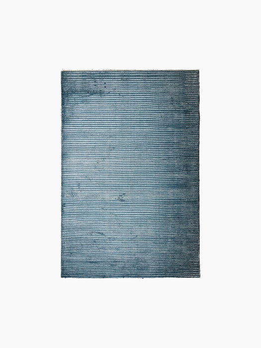 A top-down view of the Houkime Rug in Midnight Blue, highlighting its horizontal ribbed texture against a black background.