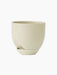 Angled view of the Hydrous Planter O20 in Ashen, a rounded, cream ceramic pot with a drainage spout and matching saucer.