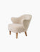 A three-quarter view of the Ingeborg Lounge Chair in fluffy, off-white Sheepskin Moonlight with four angled natural oak legs.