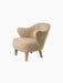 A studio shot of the Ingeborg Lounge Chair in honey sheepskin with curved armrests and light oak legs, from an angle.