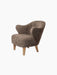 Angled view of the Ingeborg Lounge Chair in textured, brown Sahara sheepskin with light oak legs on a black background.