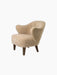 A three-quarter view of the Ingeborg Lounge Chair in textured honey sheepskin with sculptural arms and dark oak legs.