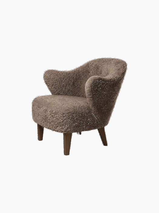 Angled view of the Ingeborg Lounge Chair, upholstered in textured Sahara sheepskin with four dark-stained oak legs.
