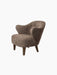 Angled view of the Ingeborg Lounge Chair, upholstered in textured Sahara sheepskin with four dark-stained oak legs.