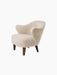 Angled view of the Ingeborg Lounge Chair, upholstered in fluffy off-white Moonlight sheepskin, with dark-stained oak legs.