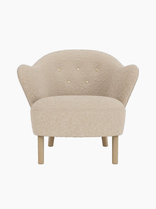 Front view of the Ingeborg Lounge Chair, light beige textured upholstery, button-tufted back and natural oak legs.