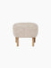 Front view of the Ingeborg Ottoman, upholstered in fluffy off-white Sheepskin Moonlight, with four short natural oak legs.