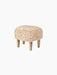 Ingeborg Ottoman, Sheepskin, shown from the side. The ottoman has a plush, honey sheepskin top and four natural oak legs.