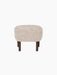 A front view of the Ingeborg Ottoman, upholstered in fluffy, off-white Moonlight sheepskin with four dark stained oak legs.