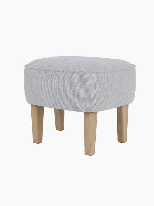 The Ingeborg Ottoman viewed from a three-quarter angle, upholstered in light grey Fiord 751 with natural oak legs.