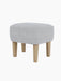 The Ingeborg Ottoman viewed from a three-quarter angle, upholstered in light grey Fiord 751 with natural oak legs.