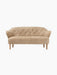 A front view of the Ingeborg Sofa, upholstered in textured honey sheepskin. It has a buttoned back and natural oak legs.