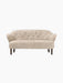 Front view of the Ingeborg Sofa in Moonlight sheepskin upholstery. The elegant sofa has a buttoned back and dark wood legs.