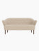 Front view of the Ingeborg Sofa in a textured light beige fabric with a buttoned back, flared arms and smoked oak legs.