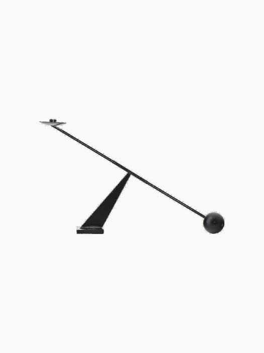 Front view of the black Interconnect Candle Holder. A rod with a candle plate is balanced on a triangular base by a sphere.