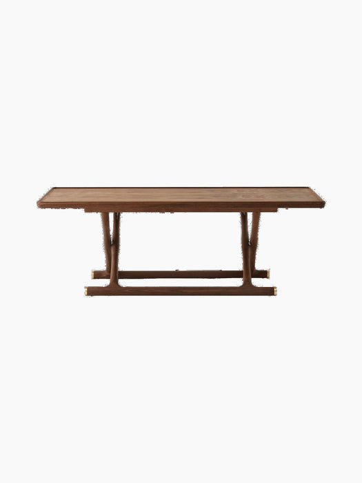 A front-on studio shot of the Jäger Lounge Table in walnut, displayed against a black background, highlighting its design.