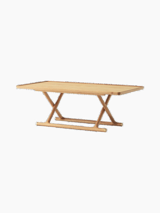 Angled Jäger Lounge Table in natural oak, with a rectangular top and foldable base with criss-cross X-shaped legs.
