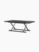 The Jäger Lounge Table in black stained oak shown at an angle, with a rectangular top and foldable X-frame base.