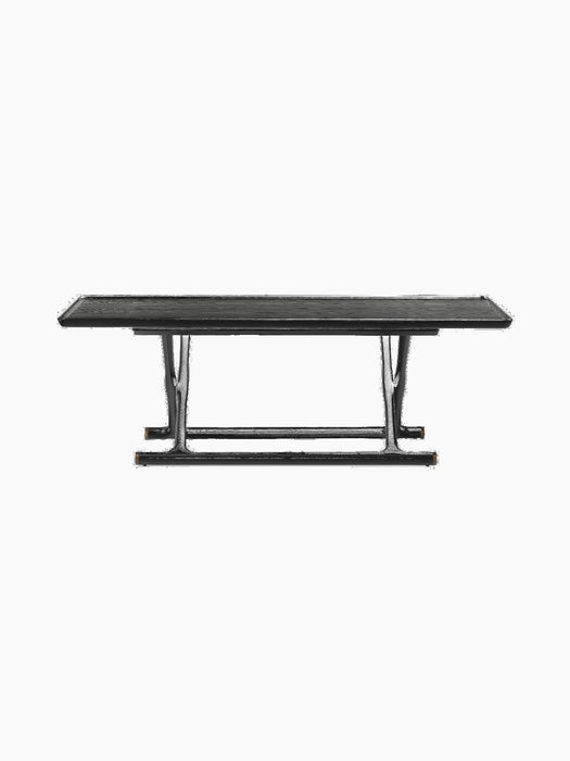 Front view of the Jäger Lounge Table in black stained oak, highlighting its foldable legs and brass details.