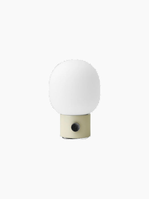 The JWDA Table Lamp, Portable, in Alabaster White, with a cylindrical base, black dimmer knob, and an elliptical glass shade.