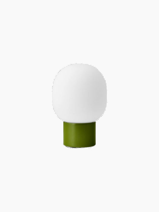 Rear view of the dusty green JWDA Table Lamp, Portable, showing its cylindrical steel base and elliptical white glass shade.